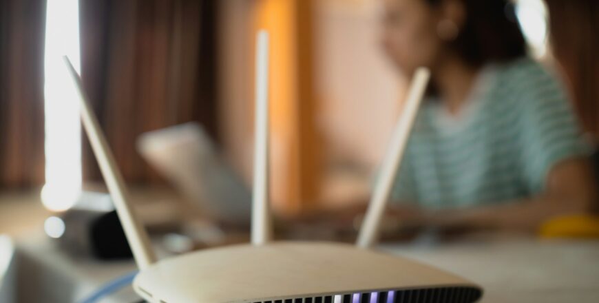 A woman is working at home using a modem router, connecting the Internet to her laptop.