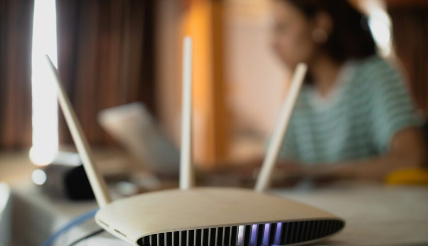 A woman is working at home using a modem router, connecting the Internet to her laptop.